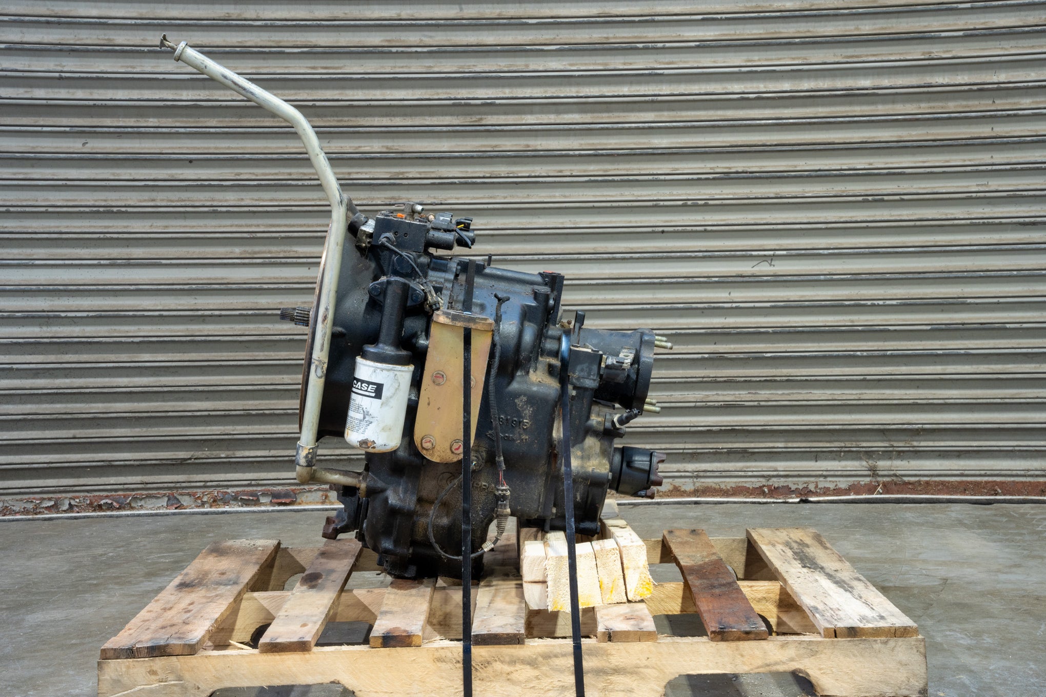 Carraro transmission on wood pallet in front of garage door left side