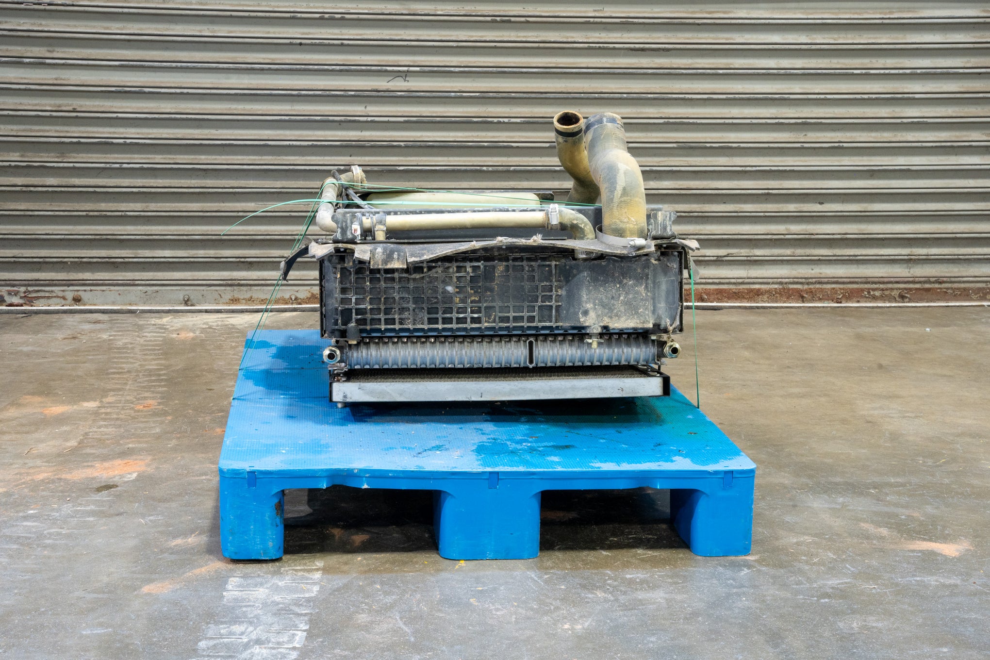 Radiator from Case 590SM Backhoe on Blue Pallet in front of Garage Door