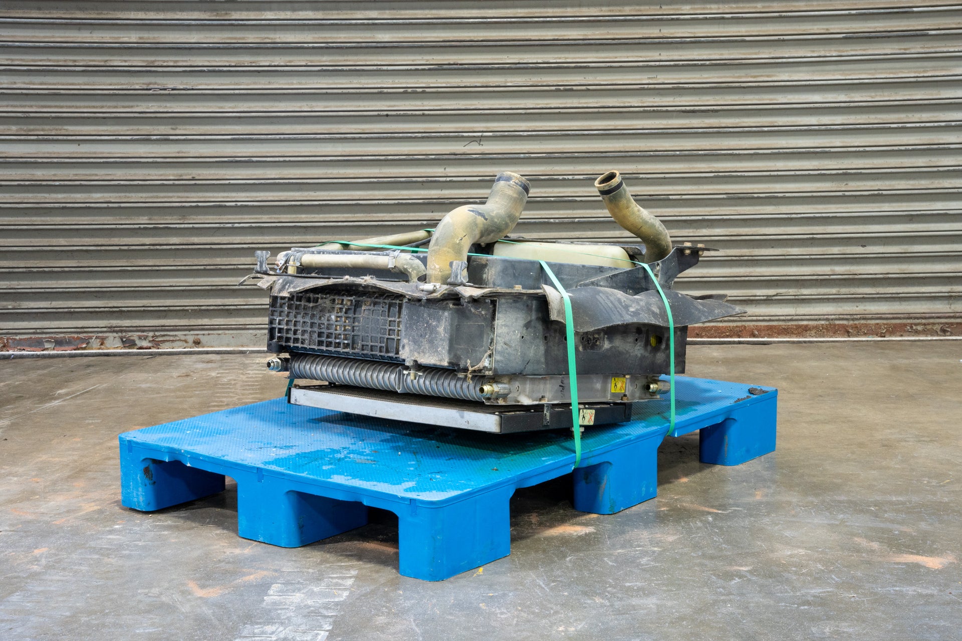 Radiator from Case 590SM Backhoe on Blue Pallet in front of Garage Door