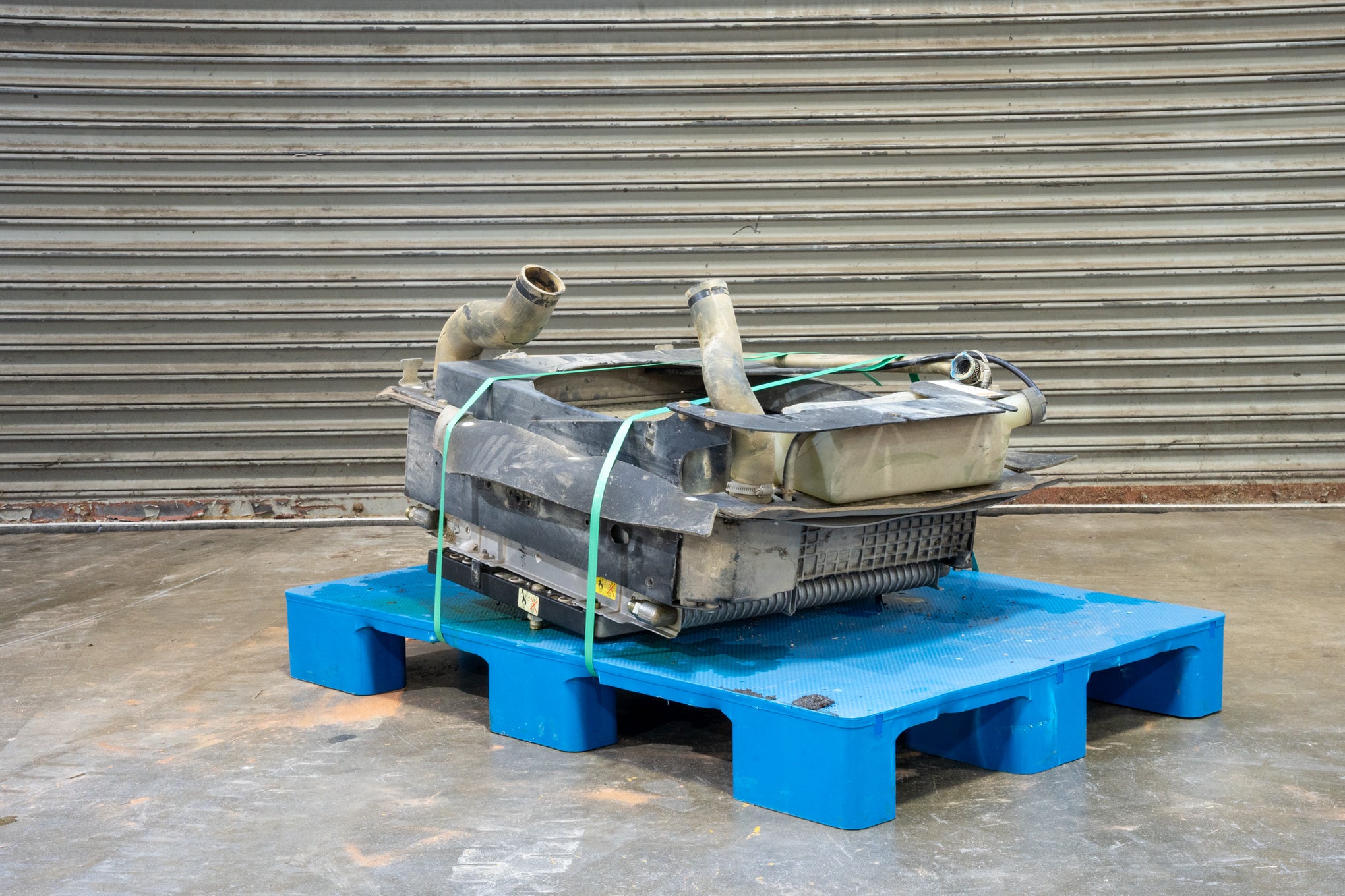 Radiator from Case 590SM Backhoe on Blue Pallet in front of Garage Door