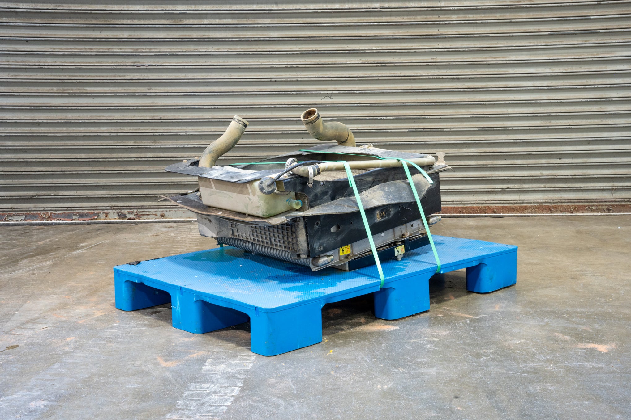 Radiator from Case 590SM Backhoe on Blue Pallet in front of Garage Door