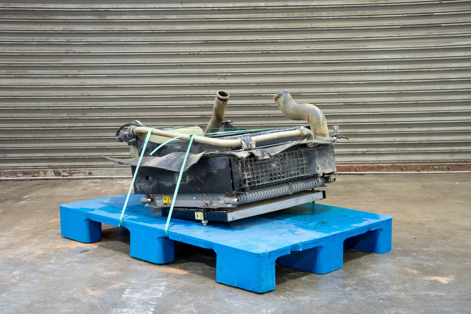 Radiator from Case 590SM Backhoe on Blue Pallet in front of Garage Door