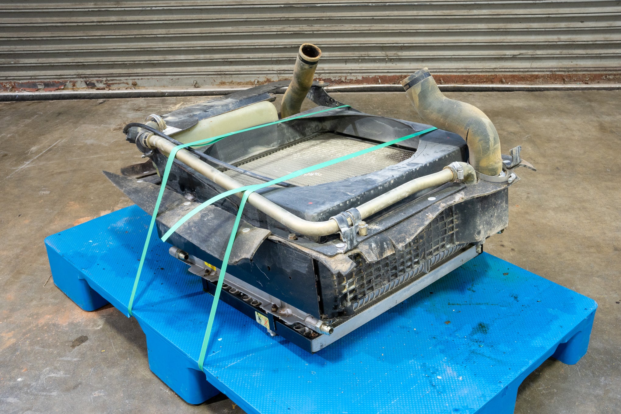 Radiator from Case 590SM Backhoe on Blue Pallet in front of Garage Door